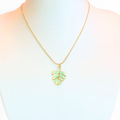 Necklace with a green leaf pendant on a mannequin with a white background